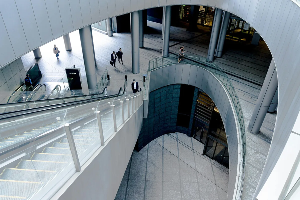 Stockimage of people walking in a big, official corporate buyilding.