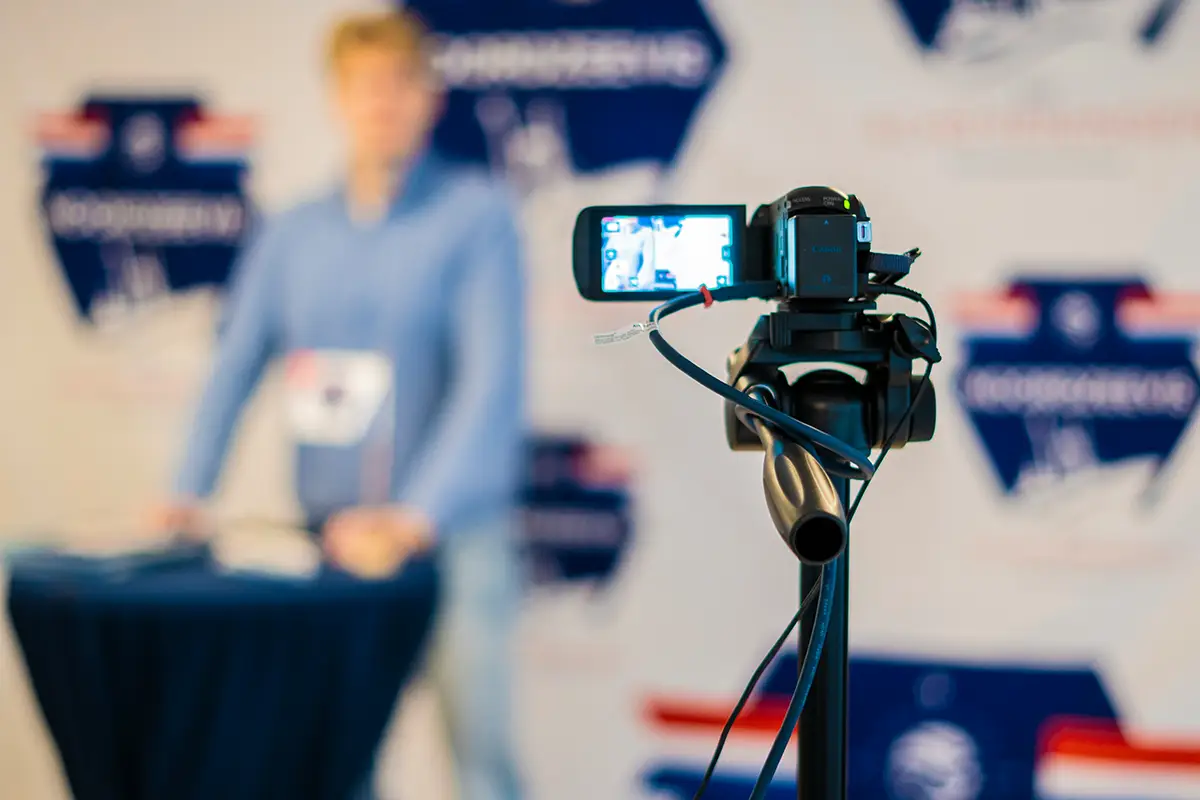 Stockimage of a ebinar being recorded with focus on the camera screen, background blurred.